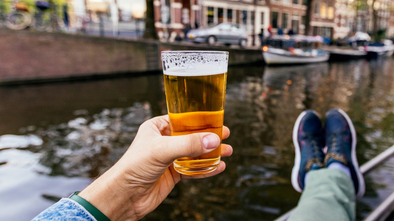 A man's hand holding a beer glass