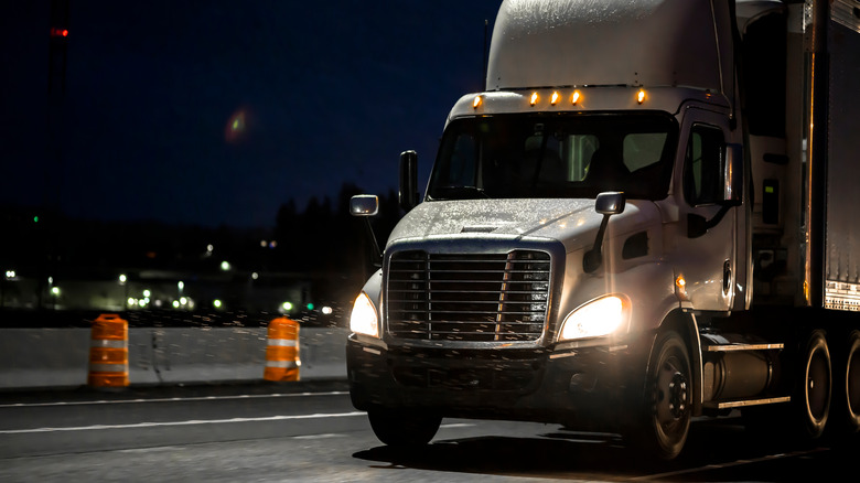 A truck drives at night