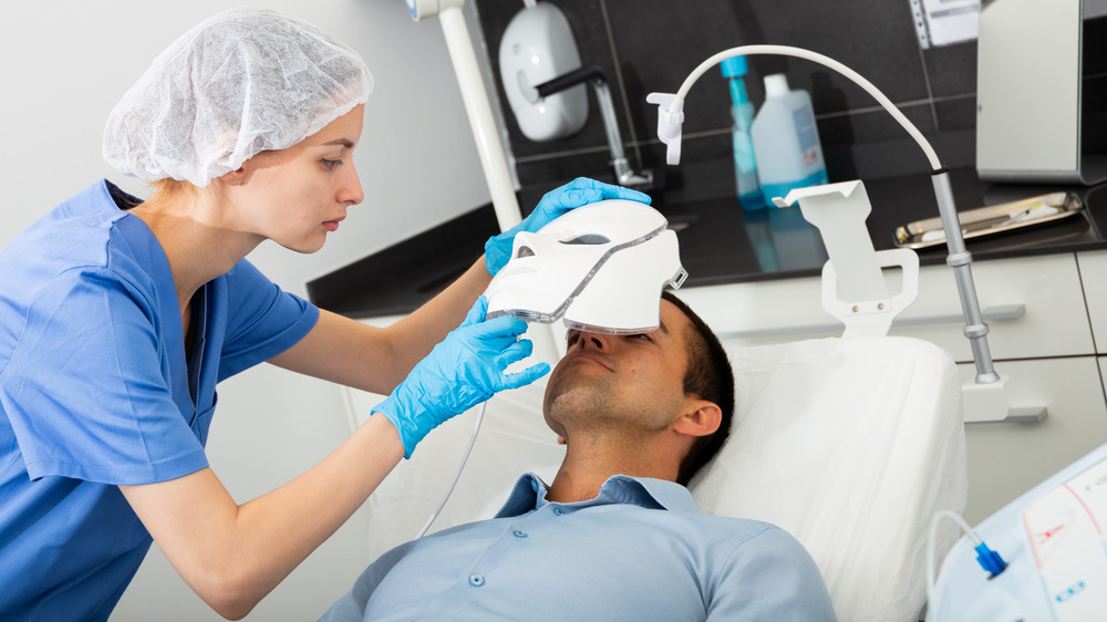 Nurse applying LED light mask