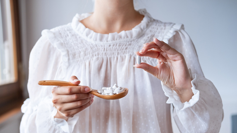 Woman holding magnesium pill
