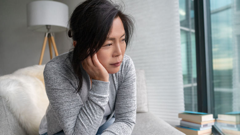 mature woman on her couch struggling with anxiety 