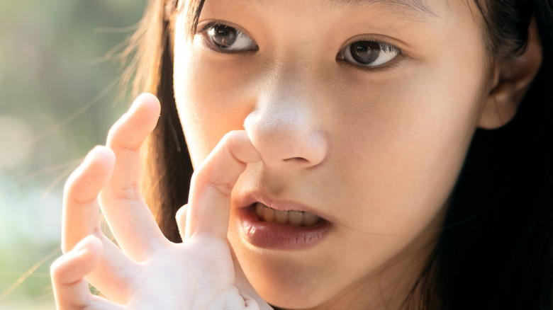 woman picking her nose