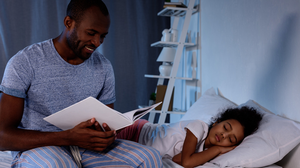 man reading while sitting on bed