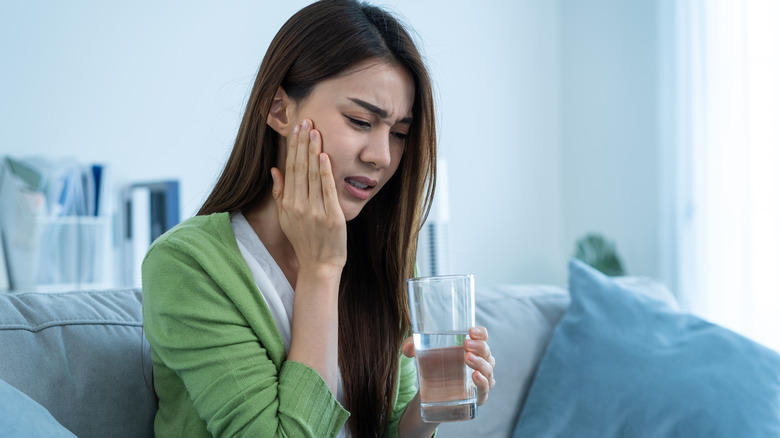 Woman with toothache holding water