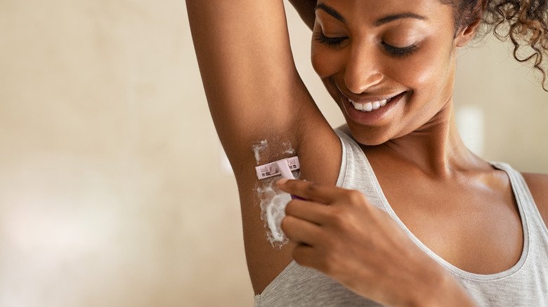 A woman shaves her armpits