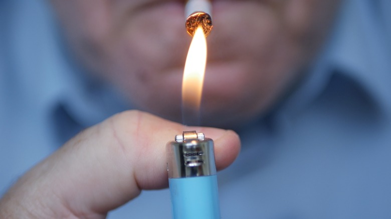 close up of a person lighting a cigarette with lighter