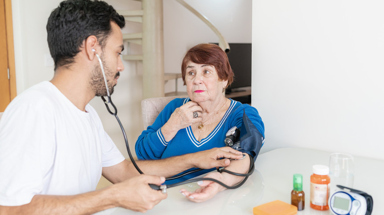 Doctor taking woman's blood pressure