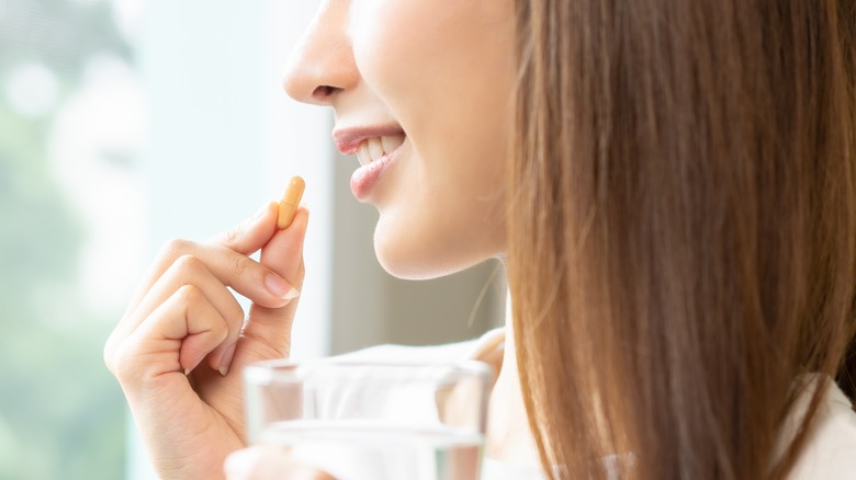 Smiling woman taking supplement