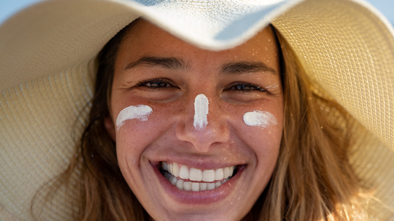 woman outside wearing hat and sunscreen