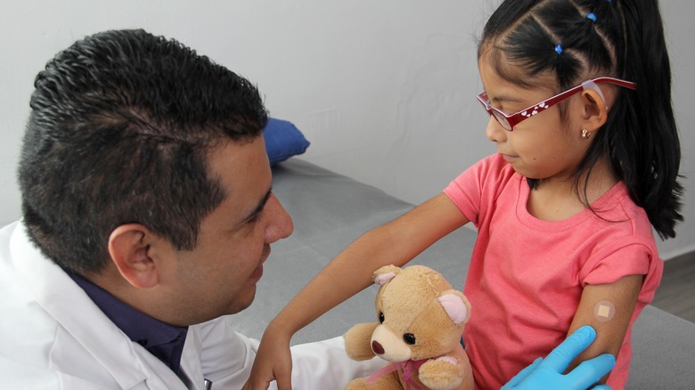Doctor applying bandaid to child's arm