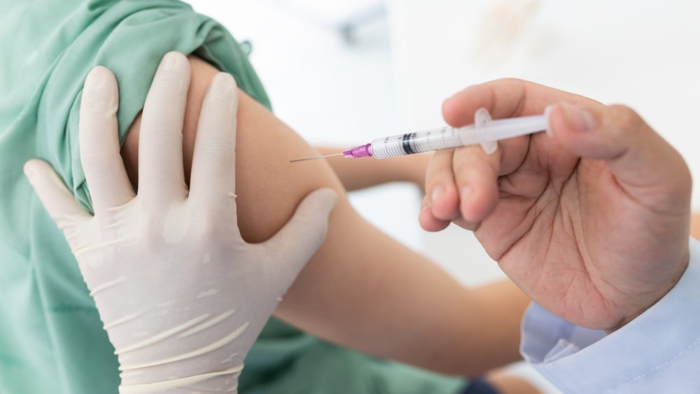 A person receives a vaccine in the arm