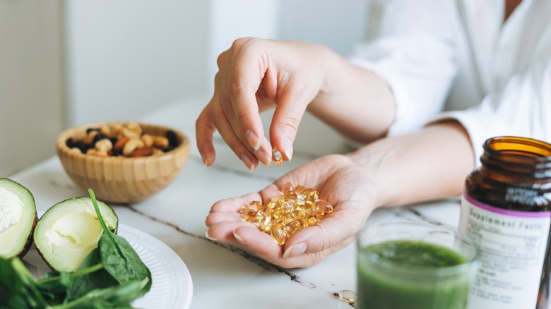 Someone holds a handful of vitamin D capsules