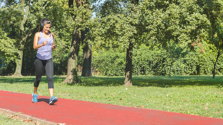 A woman walks briskly on a track