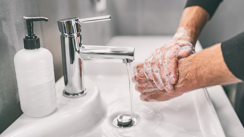 Man washing h ands in sink