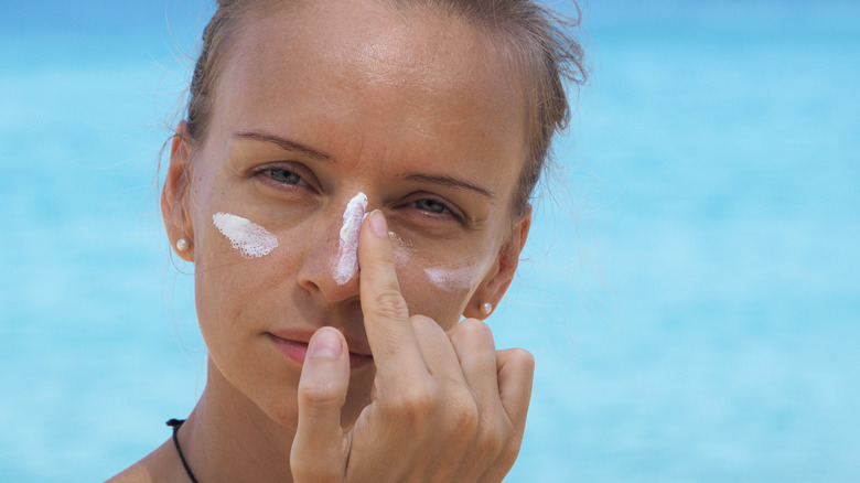 Woman applying sunscreen to face