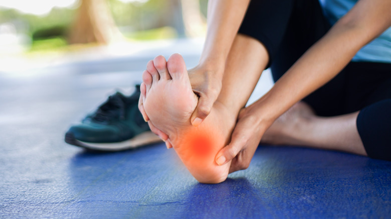 Woman feeling pain on bottom of foot