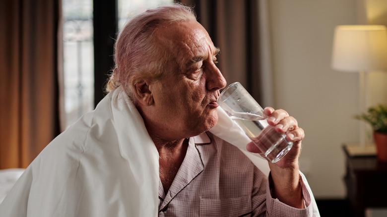 Man drinking water in bed