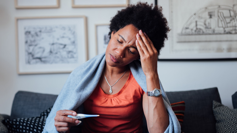 Sick woman holding thermometer 