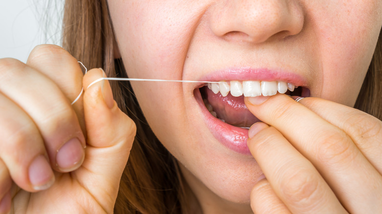 Girl flossing teeth