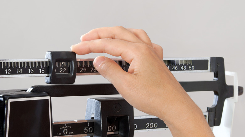 hand adjusting doctor's medical scale