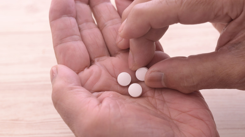 man holding aspirin in his hand