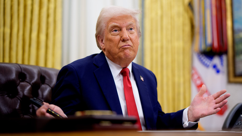 President Donald Trump gesturing while speaking during an executive order signing event in the Oval Office of the White House