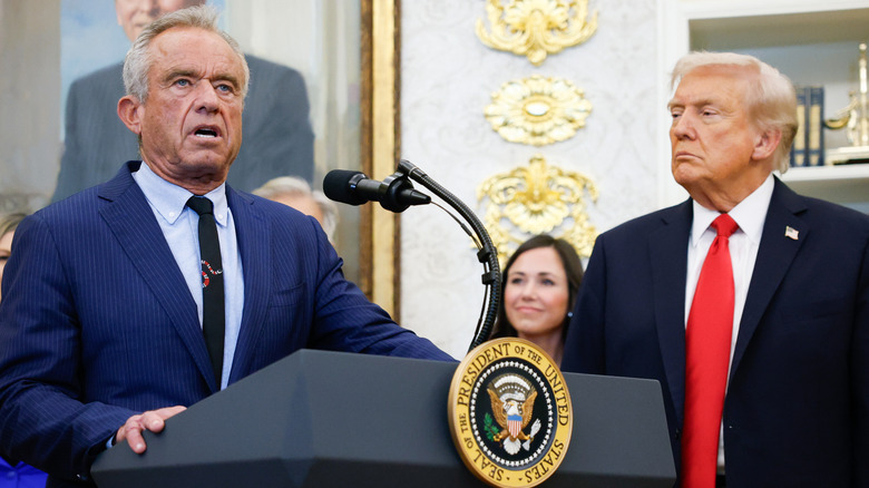 RFK Jr. speaking at a podium with Donald Trump to his side.