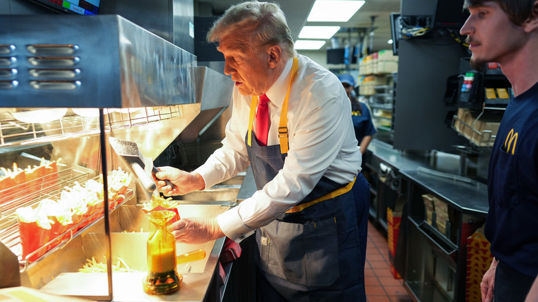 Donald Trump dispensing fries into a paper serving container