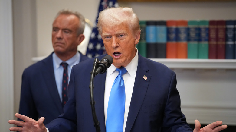 Donald Trump speaking at a podium about aspirin next to Robert F. Kennedy Jr.