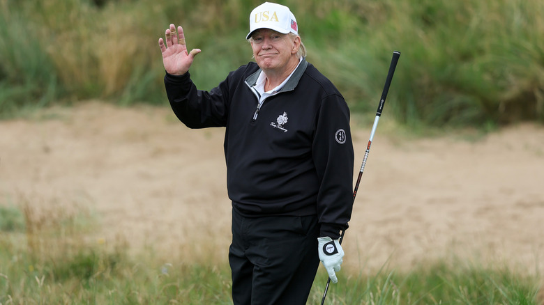 Donald Trump holds a driver after teeing off during the opening of his new golf course at his Trump International Golf links resort on July 29, 2025 in Balmedie, Scotland.