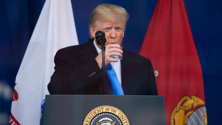 Donald Trump taking drink during speech on stage