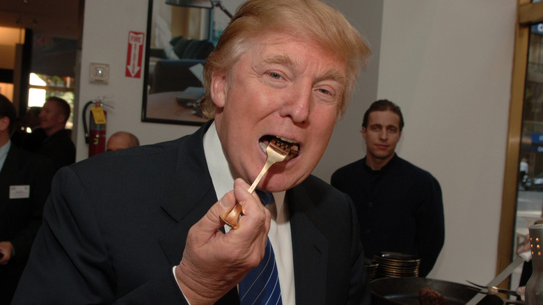 Donald Trump taking a forkful of food in a restaurant