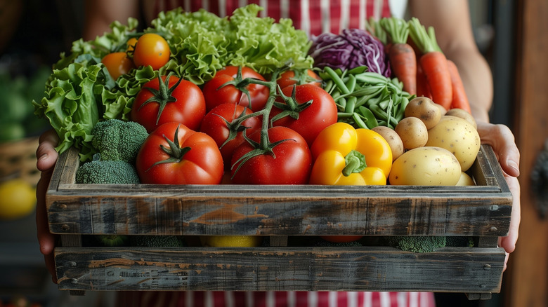 woman holding box of vegetables