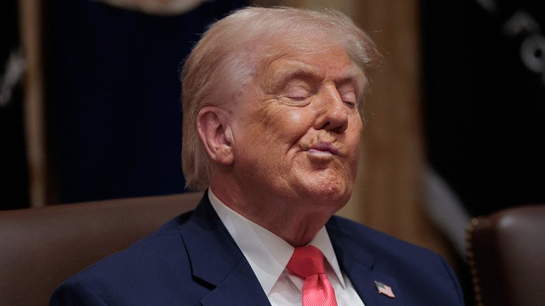 Donald Trump with his lips pinched and pursed to the side with his eyes closed.