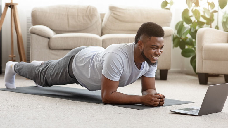 man doing forearm plank in his home