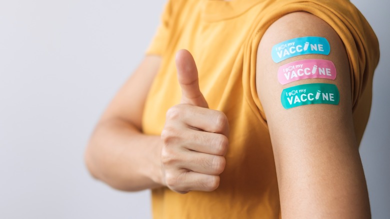 arm with three vaccine bandaids