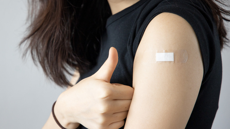 Woman giving the thumbs up on vaccination