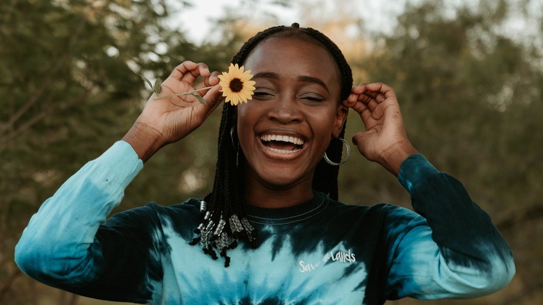 Girl holding a flower and smiling