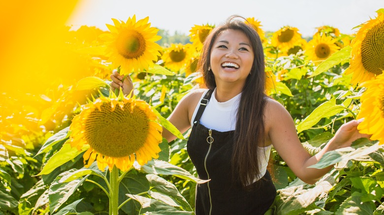 Smiling woman in field of sunflowers