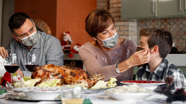 Family wearing masks at Thanksgiving dinner