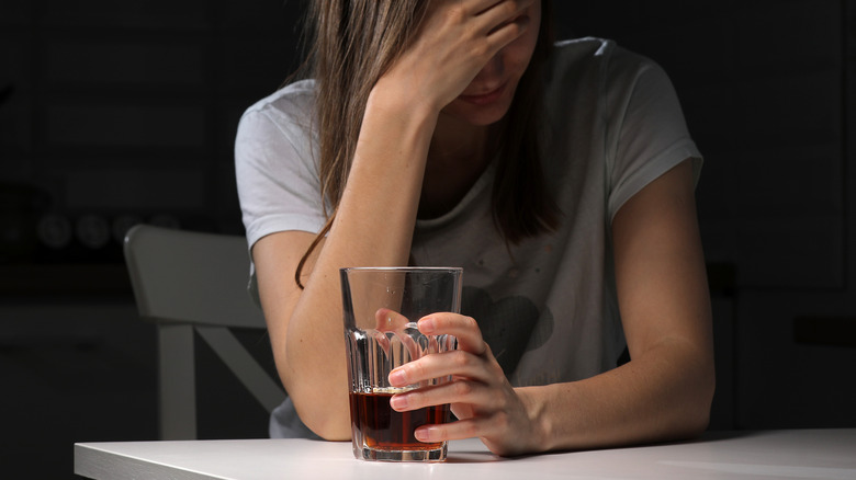 Woman sitting at a table holding a glass