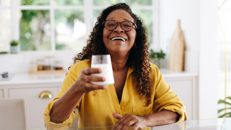 smiling woman holding a glass of milk