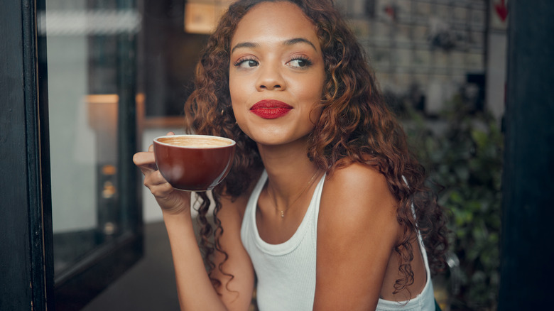 Woman drinking coffee looking away