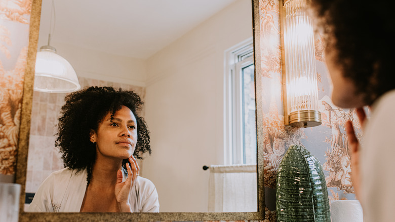 young woman looking in mirror