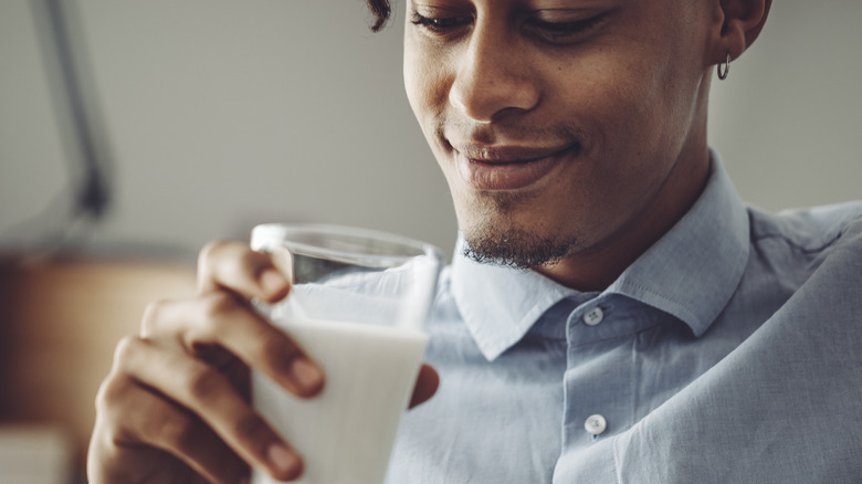 Smiling man holding glass of milk