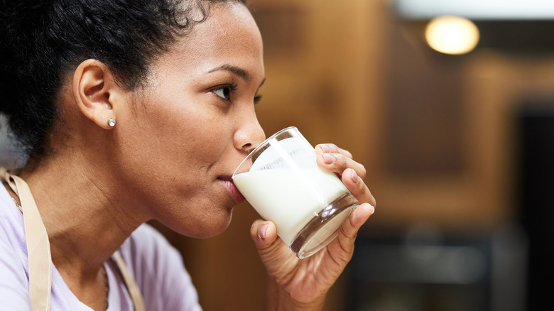 woman drinking a glass of milk at home