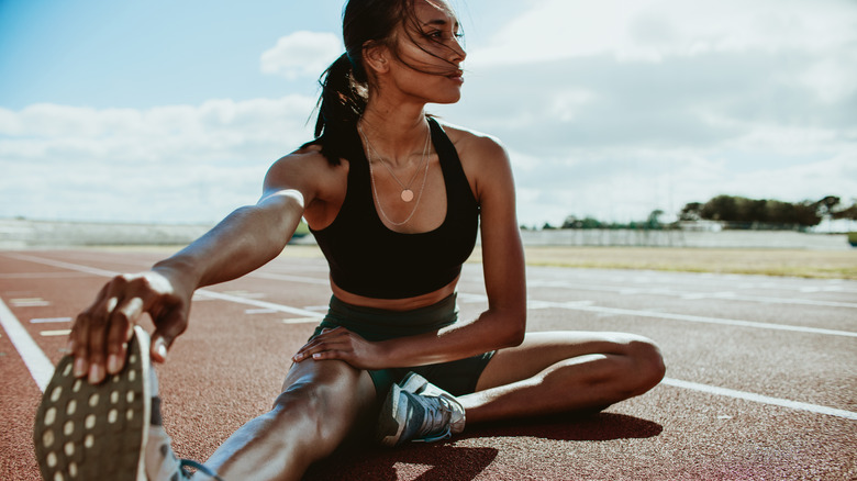 female athlete stretching on track