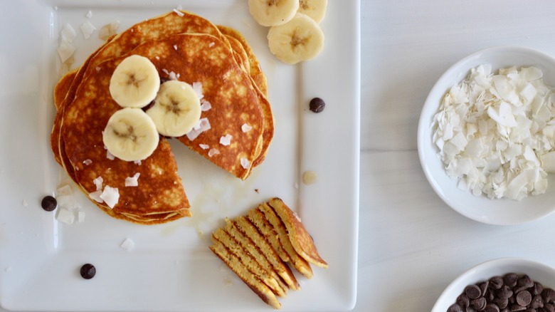 Stack of golden brown pancakes on a white plate