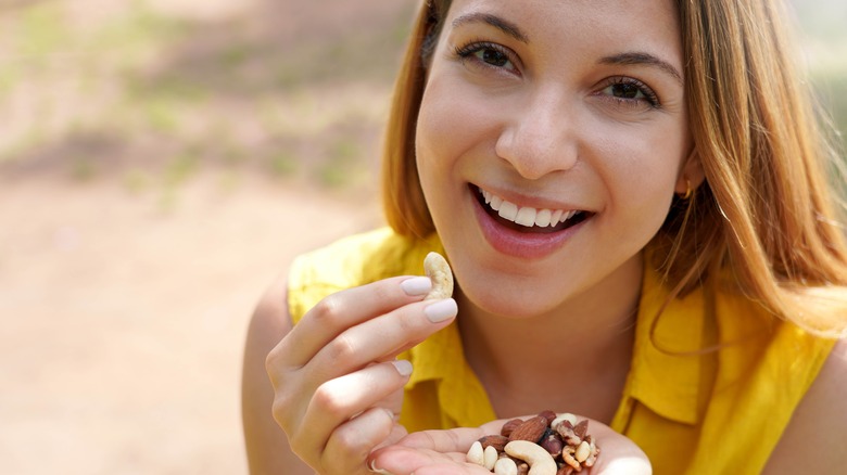 woman eating a handful of nuts