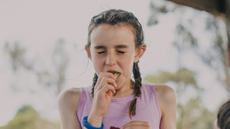 girl eating sour candy